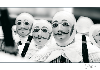 trois gilles masqués en noir et blanc binche