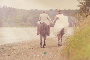 mariés à cheval près d'un lac